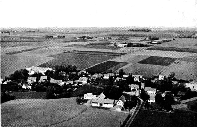 (Foto). Landsby (Hejninge vest for Slagelse) udskiftet 1781–1804 ved opdeling af bymarken i firkantede lodder. Man ser udflyttede gårde spredt på de fjernere lodder nord for byen, kun enkelte gårde i byen.Luftfot. Sylvest Jensen.