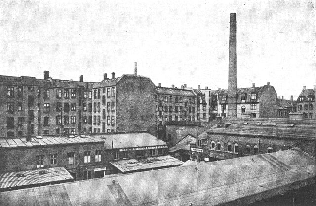 (Foto). Industrianlæg (opr. papirfabrik) på Nørrebro i København, hovedsagelig fra 1870erne. Bagved ses bagsiden af beboelseshuse fra 1880erne langs Brohusgade. Typisk sammenstuvning af industri- og boligbebyggelse fra den industrielle ekspansionsperiode sidst i 1800t.Fot. N. Elswing 1957.