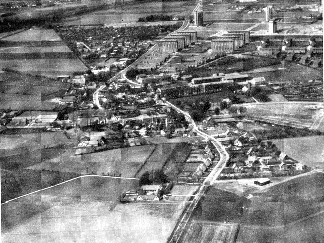 (Foto). Hvor bondelandet og storbyen mødes. Luftfotografi af Brøndbyøster fra syd 1958. I midten den gamle landsby omgivet af den »stjerneudskiftede« bymark. Man ser endnu omridset af gårdenes lodder, der vender spidsen ind mod gårdene i byen. Ejendommene mod vest drives stadig som landbrug, medens de østlige og nordlige er udlagt til bebyggelse – med høje huse mod nord nærmest S-banestationen.