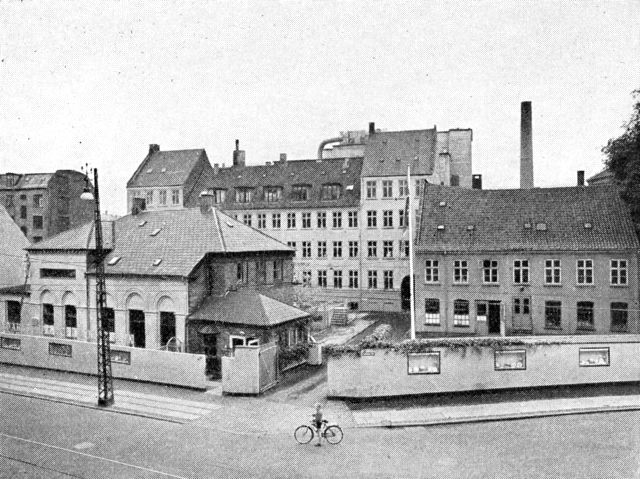 (Foto). Bing & Grøndahls Porcelænsfabrik ved Vesterbrogade med de oprindelige bygninger fra 1850erne. Bagved skimtes det helt moderne fabriksanlæg.