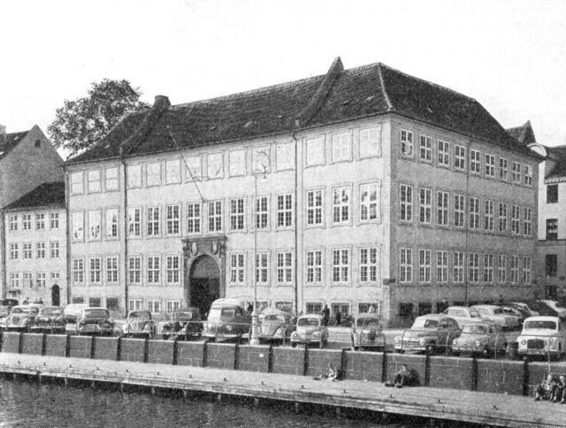 (Foto). Det kgl. Assistenshus med porten mod Nybrogade, set fra Slotsholmen. Det lavere hus til venstre er Nybrogade 4, kaldet »Pæretræet«.