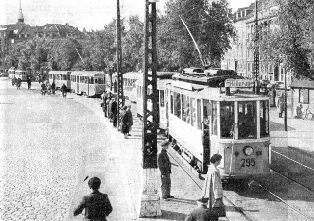(Foto). Flere sporvognstog (forrest toakslet motorvogn fra før første verdenskrig, længere tilbage bogiemotorvogn fra 1950erne) i særskilt sporareal på den af 5 forskellige sporvognslinier trafikerede strækning på Slotsholmen.
