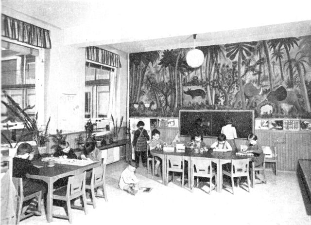 (Foto). Opholdsstue i Carlsbergbryggeriernes børnehave (indviet 1948) med vægmaleri af Hans Scherfig. Smukt eksempel på indretning af børnehave i en af hovedstadens efterhånden talrige til formålet opførte bygninger – her i tilknytning til stor erhvervsvirksomhed med mange beskæftigede mødre.