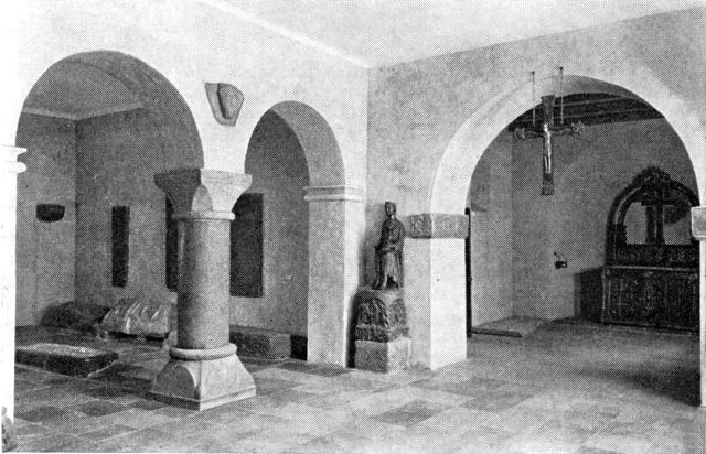 (Foto). Interiør fra Nationalmuseet, udformet ved museets nyindretning i 1930erne. Gennem buen til højre ses ind i et rum, indrettet som et jysk landsbykirkekor fra o. 1150, med det gyldne alter fra Lisbjerg. I forrummene romansk granitskulptur.