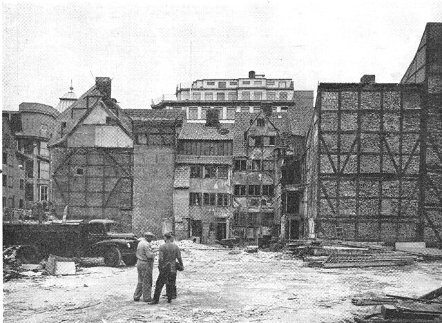 (Foto). Sanering 1958. Udsigt fra en hustomt i Aabenraa til de forladte bindingsværkshuse fra 1730erne i Landemærket og bagved det moderne Gutenberghus.