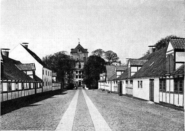 (Foto). »Bredgade« på Gjorslev med bindingsværksbygninger delvis fra Frederik IV.s tid, set fra øst mod hovedbygningen.