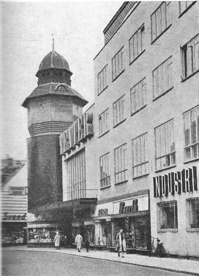 (Foto). Industribygningens façade mod Østergade med teatret; bagved ses vandtårnets top.