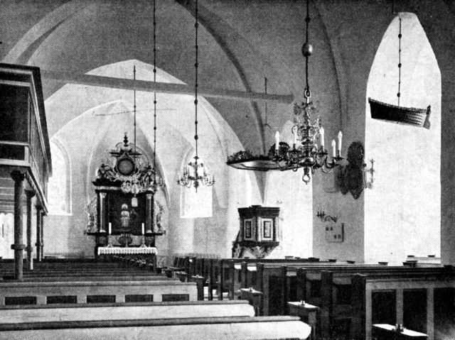 (Foto). Nibe kirkes indre. I den forreste arkade til højre ses ophængt model af en sildekåg fra 1703.