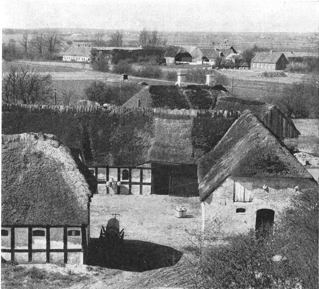 (Foto). Udsigt over en del af Helberskov by med delvis ældre bebyggelse, set fra den stejle bakke (moræneø) »Bjerget«.