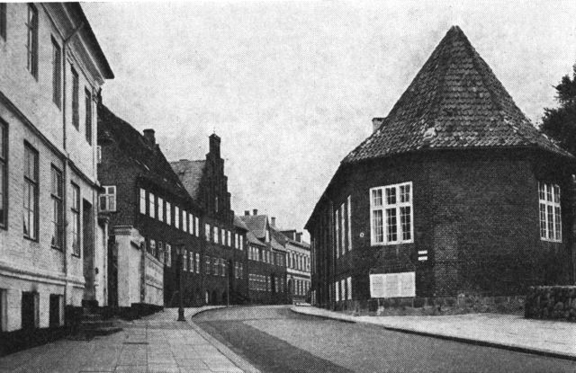(Foto). Skt. Mogensgade set fra syd. De tre huse af røde sten i gadens venstre side er nr. 7, 9 (med trappegavl) og 11. Til højre »Morvilles Gård«.