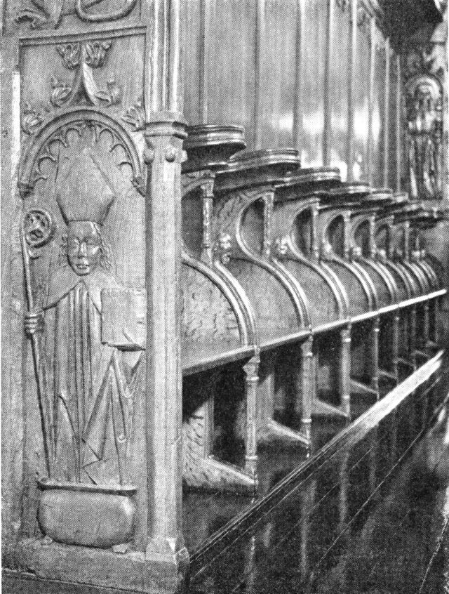(Foto). Munkestole i Klosterkirkens kor. I endestykket udskåret billede af den hellige Erasmus.