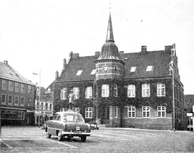 (Foto). Silkeborg rådhus, set fra Torvet. Over den holdende bil ses Michael Drewsens statue.