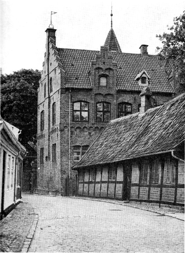 (Foto). Puggårdsgade med Tårnborg, det nuværende posthus, opført i 1540’erne, og det omtrent samtidige bindingsværkshus Puggårdsgade 5.