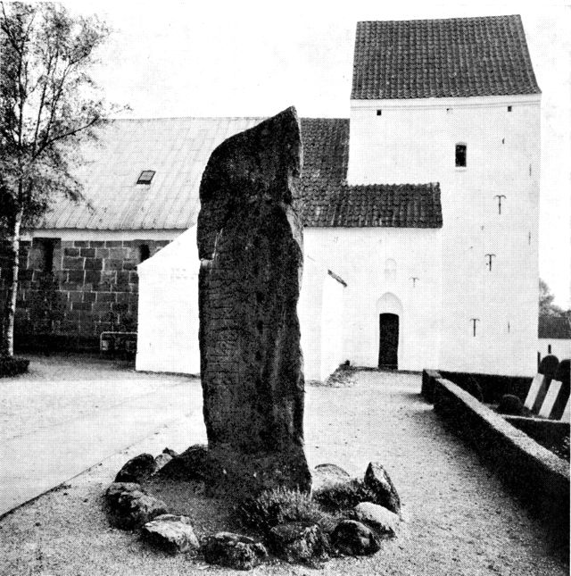 (Foto). Læborg kirke med Læborg-runestenen i forgrunden.
