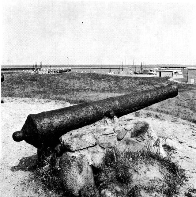 (Foto). Udsigt over en del af havneanlægget ved Havneby fra en klittop med gammel kanon, måske fra Svenskekrigenes tid.