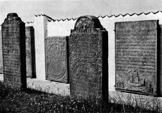(Foto). »Kommandør«-gravsten ved Rømø kirkegårds mur.