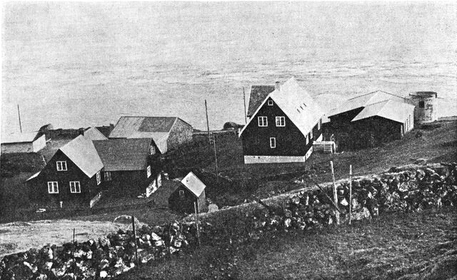 (Foto). Fra bygden Velbastaður (Streymoy), til højre moderne bondegård med udhuse og ensilagebeholdere.