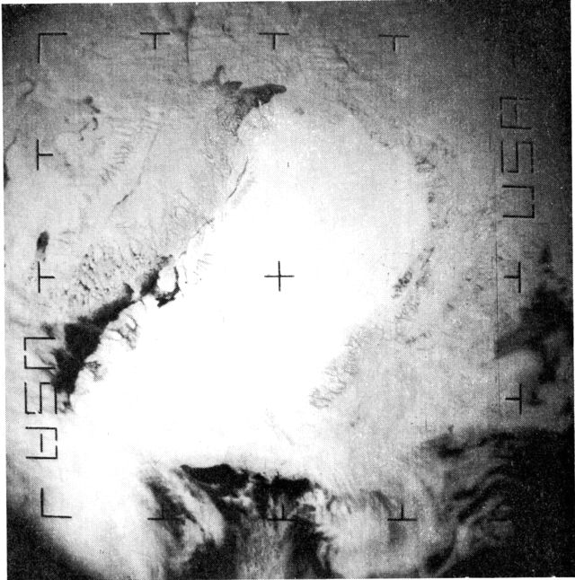 (Foto). Drivissituationen omkring Grønland 26/4 1969 kl. 14,53 fot. fra satellitten Essa 8 i 1.400 km’s højde. Storisen ses at blokere Øst-G. og når næsten over til Island. Vestisen når kysten af Vest-G. n. f. Disko. »Nordvandet« ud for Thule og Sydvest-G.s åbne kyst træder tydeligt frem. Kap Farvel er indhyllet i skyer. (Billedet nedtaget på Iscentralen Narssarssuaq).